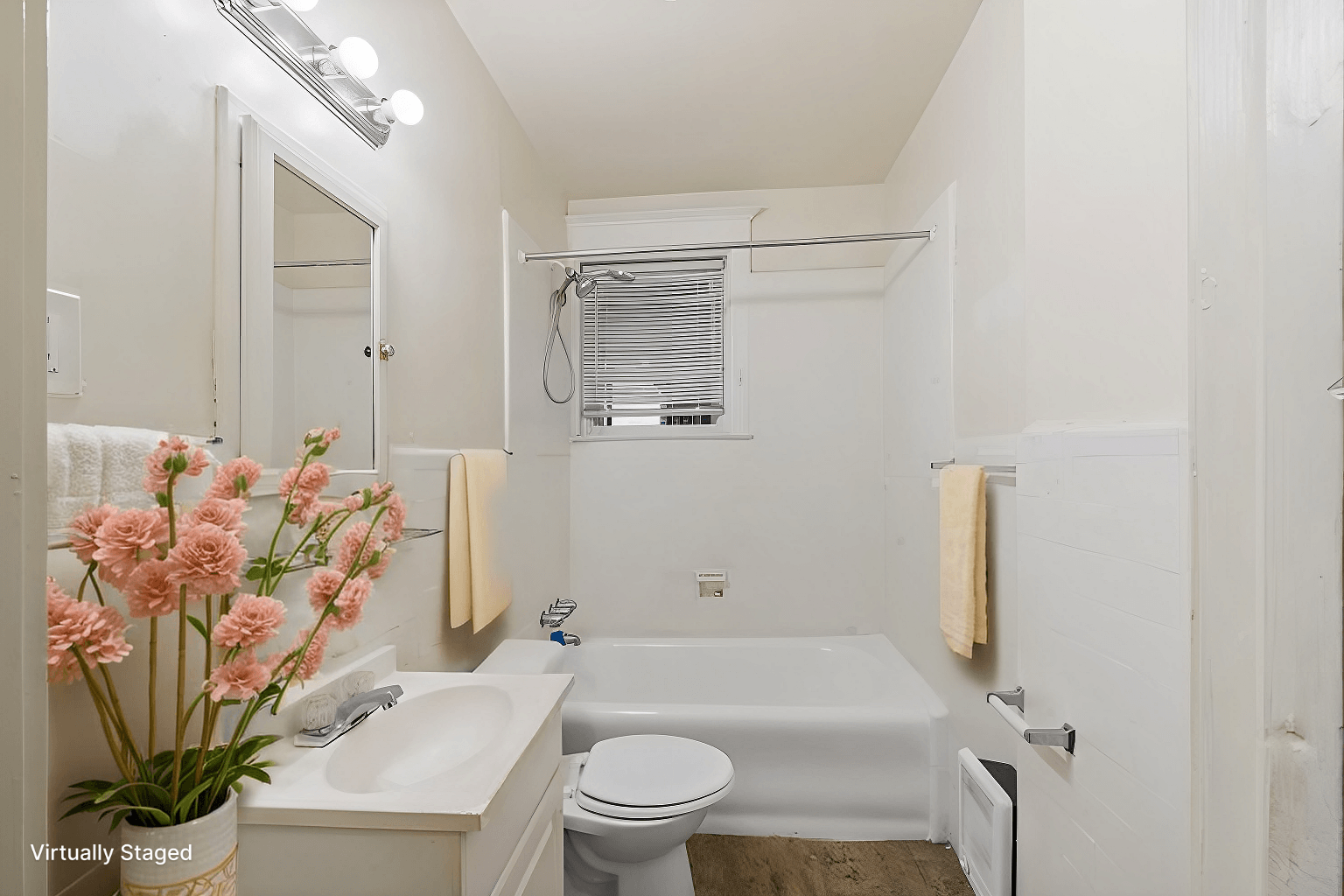A white bathroom with a tub, toilet, sink, and flowers.